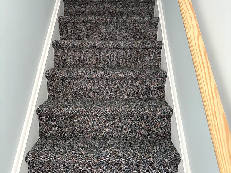The carpeted steps that lead upstairs