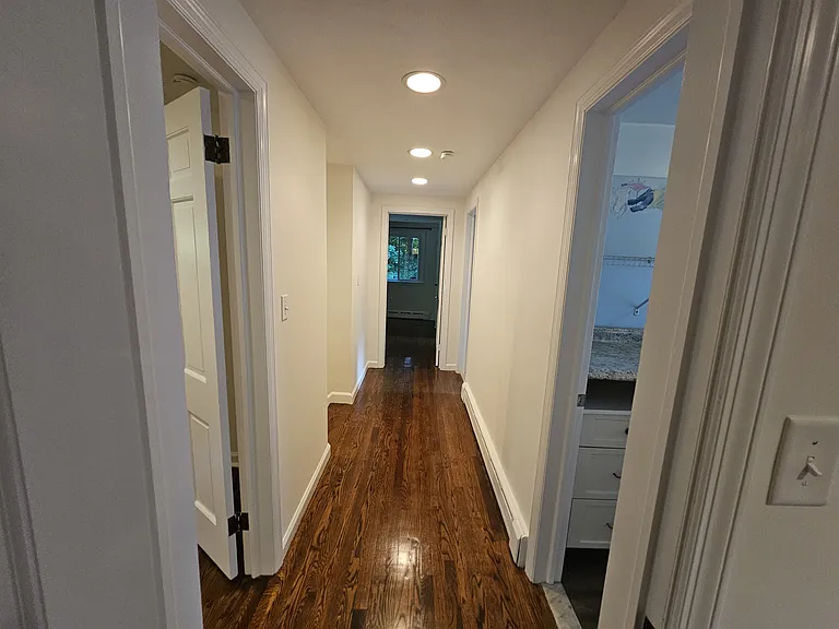 First Floor Hallway _ View 2
with Bedroom 3 on the left, Bedroom 2 directly ahead, the laundry area on the right, and the bathroom farther down on the right.