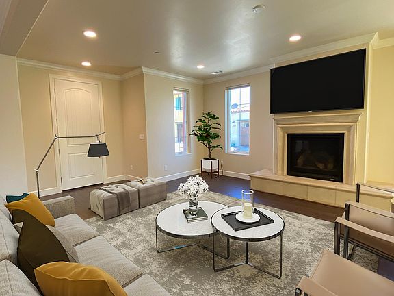Large, modern living room with gas fireplace, high ceilings and crown molding.