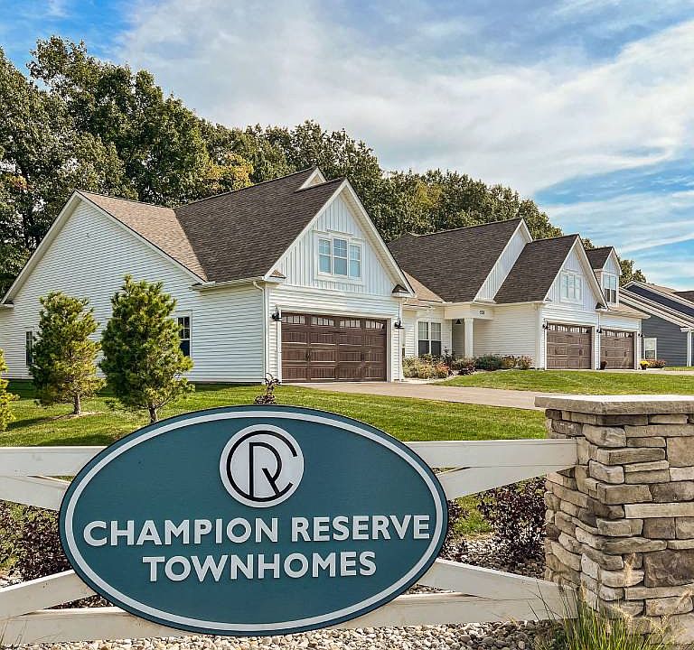 Exterior of Champion Reserve Townhomes near the Gillis Road entrance. White townhomes with attached 2-car garages.