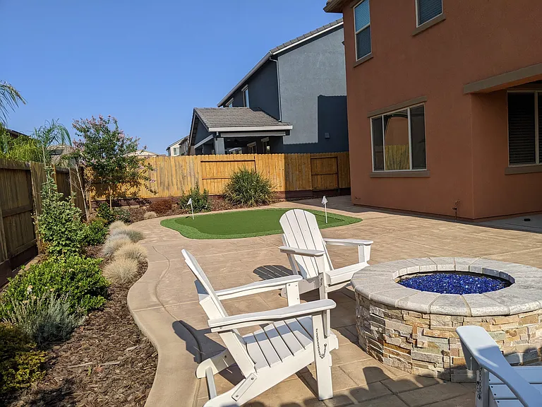 Elevate your weekends with a professional-grade backyard putting green. This meticulously maintained outdoor area blends leisure with luxury, offering a resort-style experience right at home with a fire pit and patio seating.