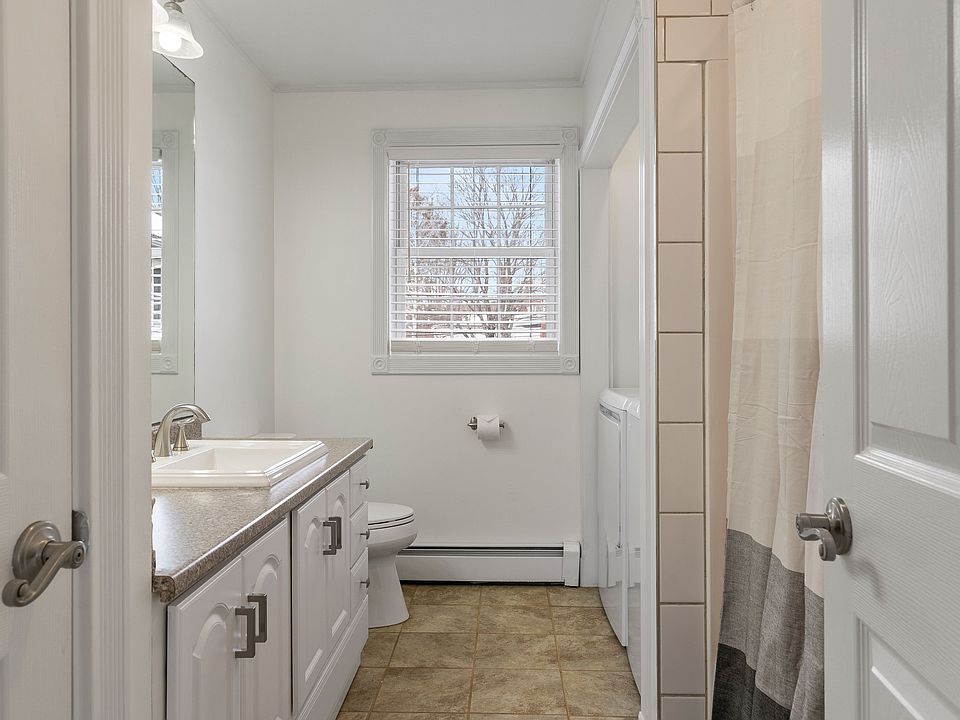 Full Bath, In-unit Laundry, White Vanity, Tile Flooring, Shower/Tub Combo, Natural Light, Neutral Decor.