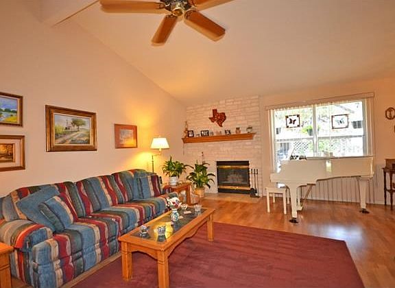 A stone fireplace and vaulted ceiling can be found in this spacious family room.