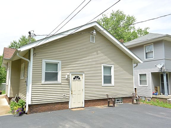 Back of house and paved parking for three cars.