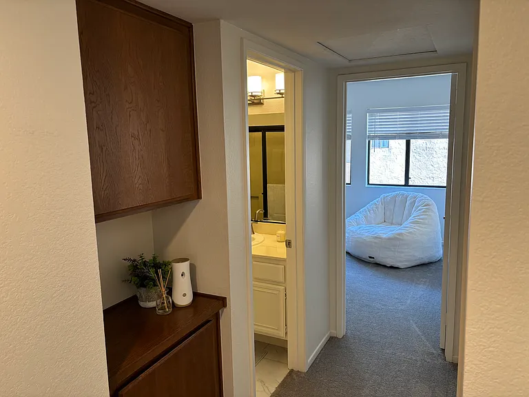 Upstairs hallway with linen cabinet. Upstairs bathroom and bedrooms at end of hallway