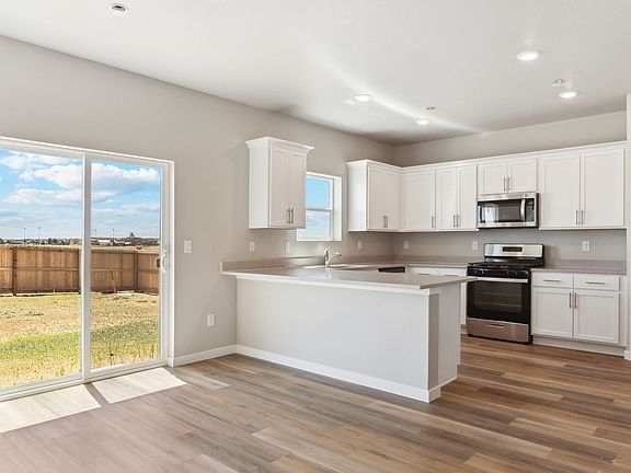 The kitchen has stainless steel appliances and white cabinets.
