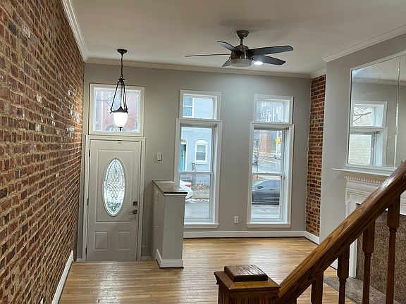 Light-filled living room with brick walls and hardwood floors.