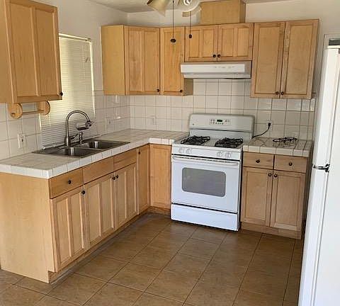 Kitchen area - gas stove, ceiling fan, door to front yard