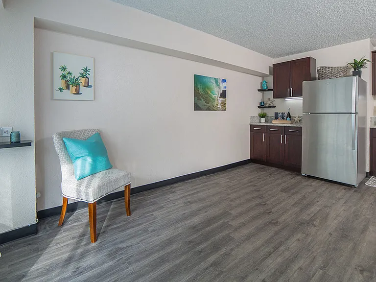 Waikiki Walina Apartments living area with decor and kitchen area with appliances, cabinets, and counters