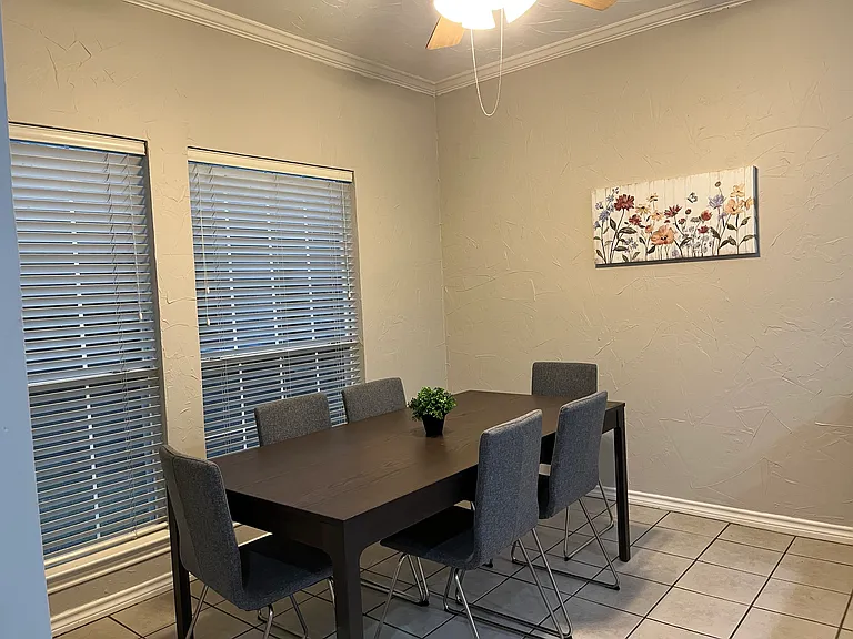 Dinette - furnished with table and six chairs, plus wall decor. Shared space.