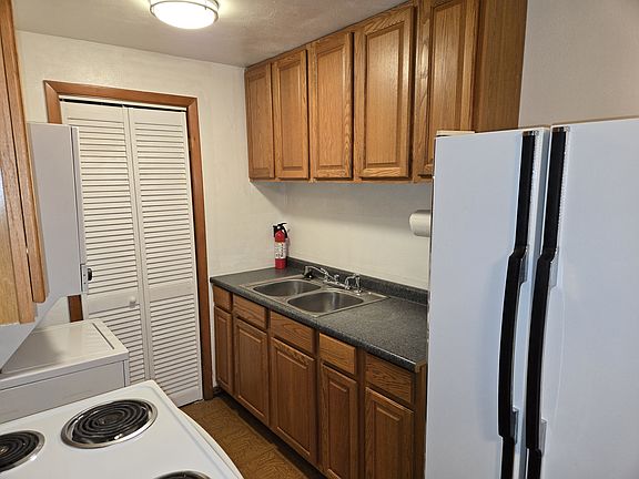 Kitchen includes refrigerator, stove, and stackable washer/dryer combination
