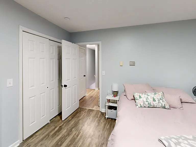 Bedroom one with large double reach-in closets. Photo is of a similar unit; available unit has the same floorplan. Furniture and decor not included.