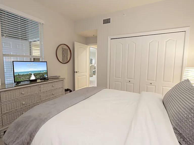 Guest Bedroom features a queen-size bed, TV, and large closet.