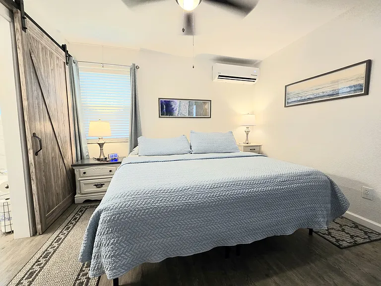 Bedroom with king memory foam bed & cooling gel topper, barn door style bathroom door is on the left.