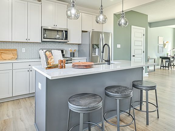 DRB Homes Rolling Hills Whitaker Model, white kitchen cabinets, gray island with sink, white counter