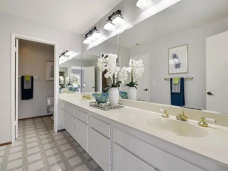 Upstairs double sink vanity with plenty of mirrors and lights for the two bedrooms. Shower tub and toilet in the next inner room.