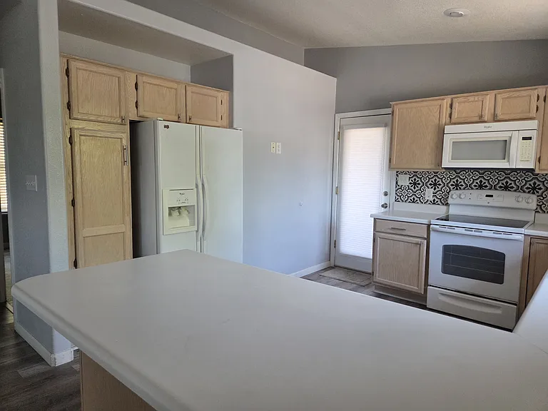Kitchen featuring large refrigerator with ice maker and pantry as well as pot shelves to hold all your favorite things.