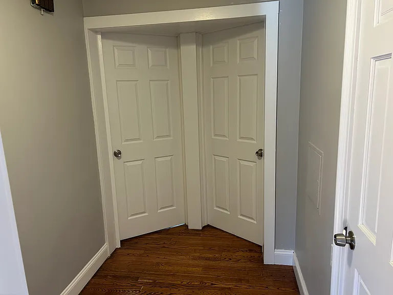 2 Bedroom doors ahead and bathroom door on right