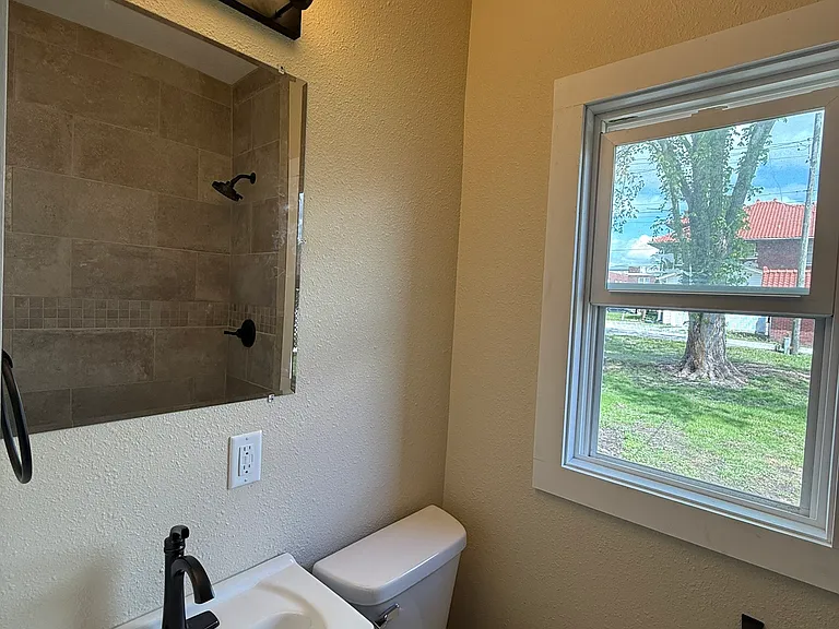 Downstairs updated bathroom with walk-in tile shower.