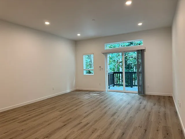 Large airy living room with sliding glass door to balcony