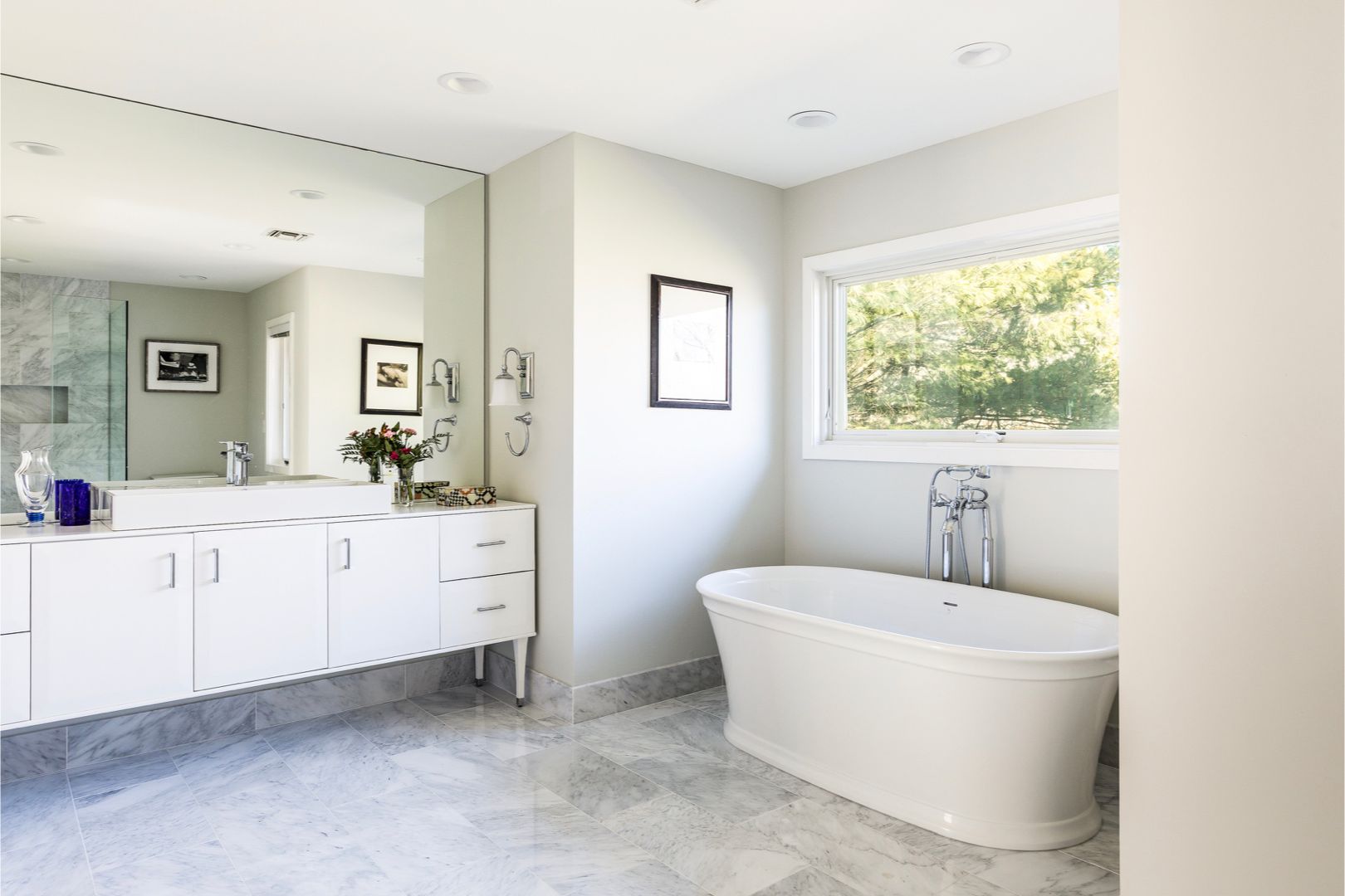 Master bathroom outfitted with marble floors. Free-standing soaking tub, walk-in rain shower