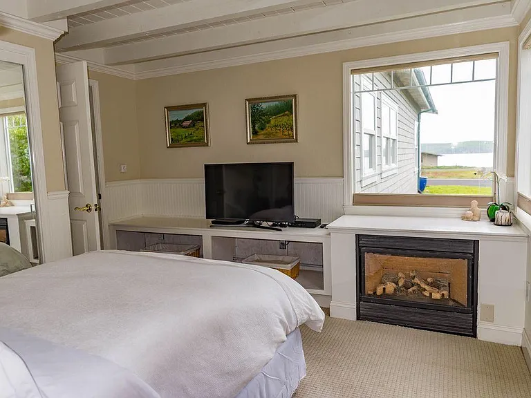 Primary En-suite bedroom with Ocean Views and gas burning fireplace.