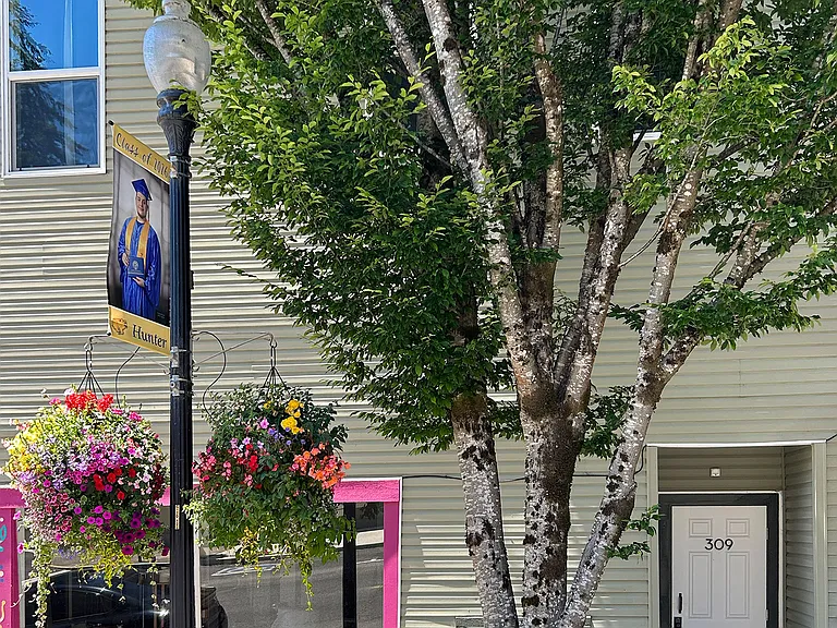 309 front door and vintage lamppost adorned with large, city-irrigated flower baskets.