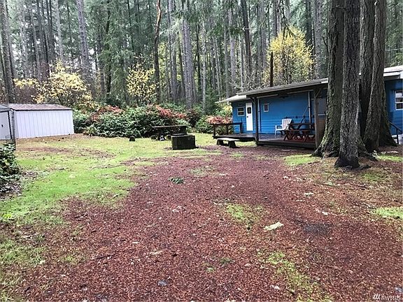 View of vintage trailer and one of the storage sheds, with the fire pit in between
