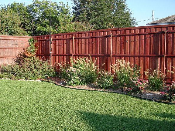 Backyard and flowerbeds with 14' privacy fence
