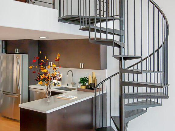 Open kitchen with quartz countertops and stainless steel appliances.