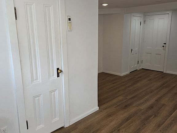 As you step inside to the left, the bathroom door is more clear and is closed. The heating/cooling remote is to the right of the bathroom door when looking at the door. Two doors to the back are the closet(left), hallway(right).