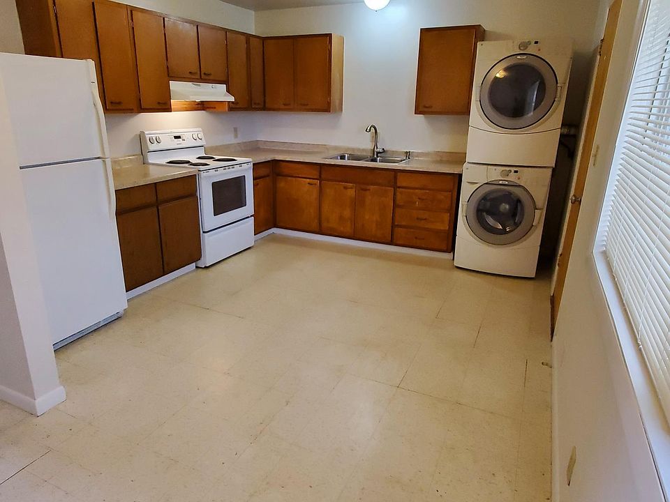 Kitchen with washer dryer. Fridge has an ice maker. Door going out to back yard is to the right of the washer and dryer.
