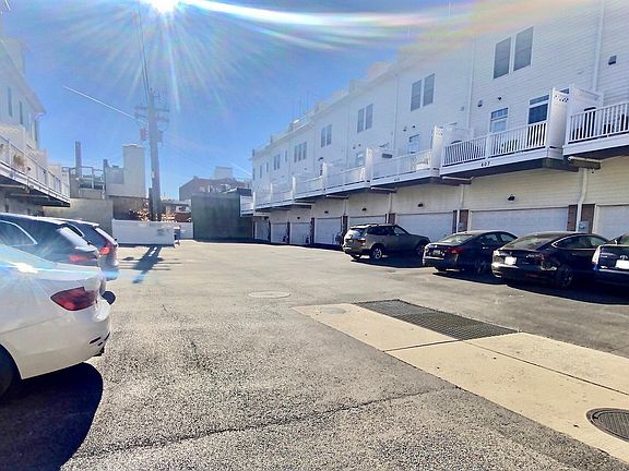 Back of home showing garages and additional parking spots