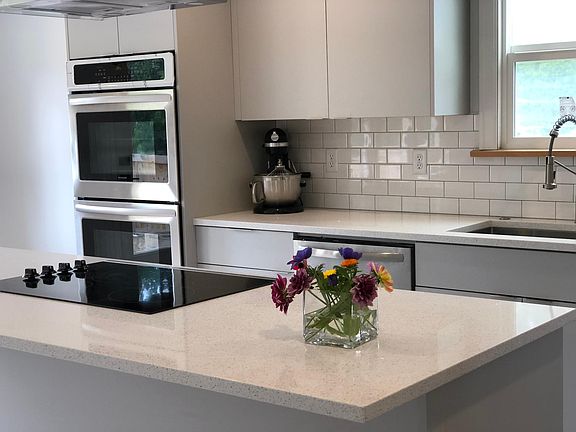 New kitchen with tons of storage (custom locally made maple cabinetry w/ soft-close cabinet doors and drawers). Plenty of counter work space for the family chef with cooktop and wall mounted double ovens.