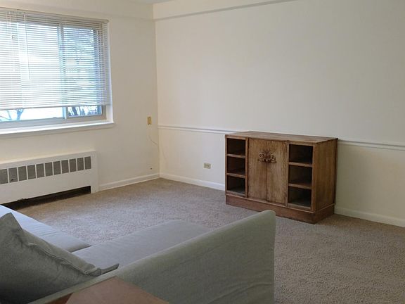 Living room with large windows. The A/C unit is in the corner on the left, just out of sight.