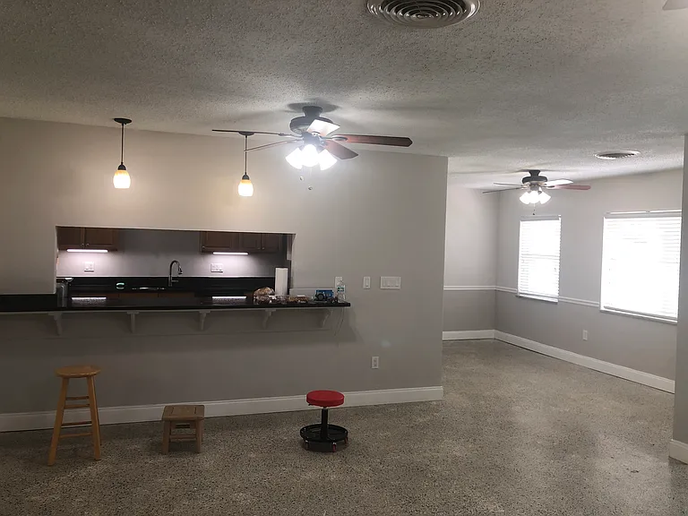 Living room, eat-at counter space, pass through. Dining or office area with chair rail.
