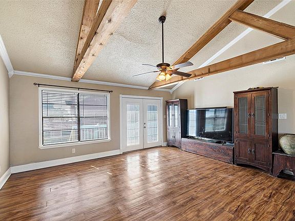 This cozy cottage has an open living/kitchen/dining floor plan that offers trendy vinyl-plank flooring, high vaulted ceilings with exposed beams & large decking along the living areas.