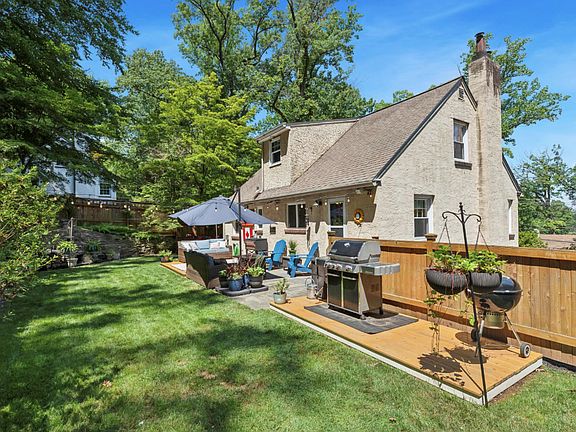 Backyard. Outdoor fireplace built into the stone wall in the far left corner.