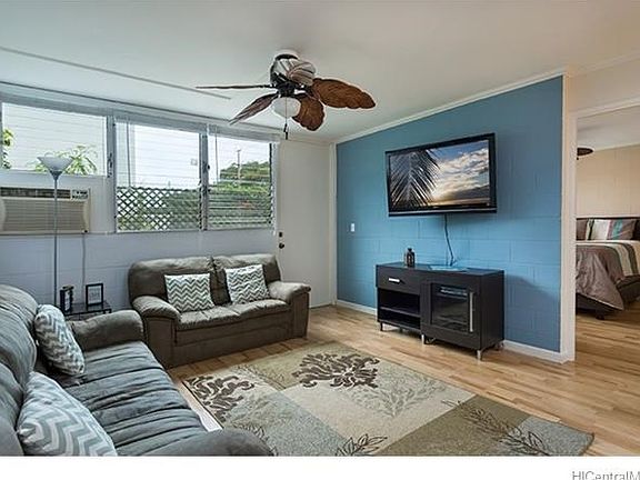 Generous living area opens onto the oversized lanai complete with waterfall and fish pond.  Master bedroom in the background.