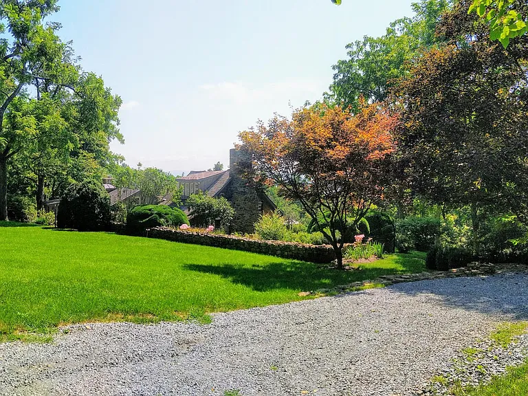 Long gravel driveway and parking area. Apartments located at the other end of the home.