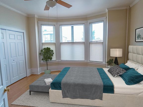 Sunny and spacious master bedroom with ceiling fan.