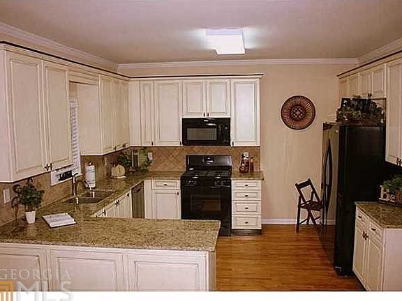 Striking kitchen with hardwoods, antiqued cabinetry, granite counters, tile backsplash! Extra built-
