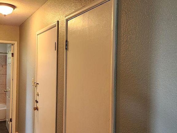 Hallway with a closet, leading to bedrooms and bathroom