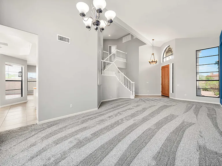 Living room with front door and open staircase
