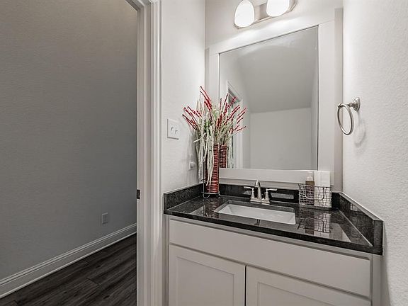 Bathroom featuring vanity, dark wood-style flooring, and a textured wall
