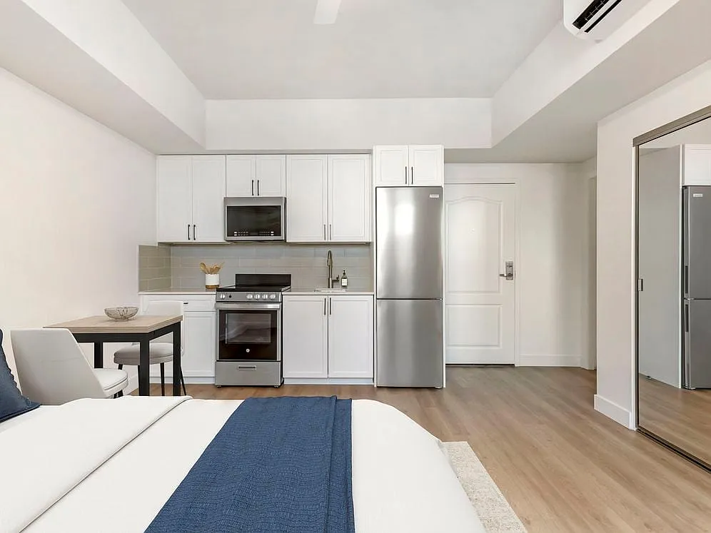 Renovated Package II kitchen, living, and dining area with hard surface flooring - Avalon Wilshire