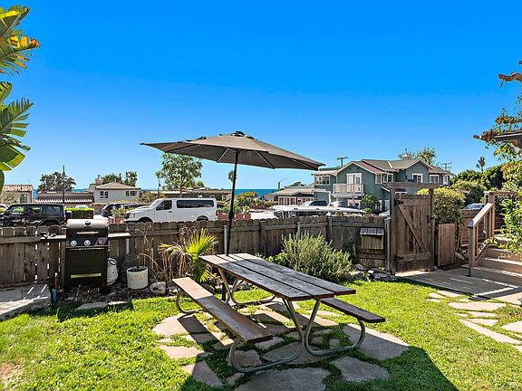 Solar powered LED lit umbrella for day or night seating, BBQ at the ready next to herb garden with rosemary, thyme, aloe, peppers, chives