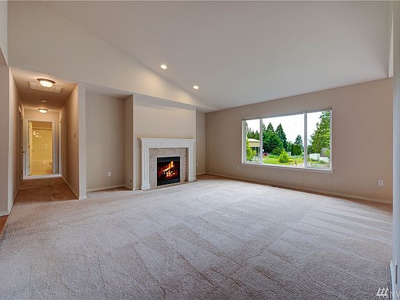 From the foyer, you will be greeted by a large living room full of natural light and a warm fireplace to gather your furniture around. 