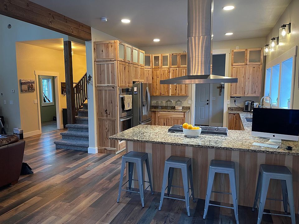 Spacious kitchen with eating bar, double wall oven, and gas range.
