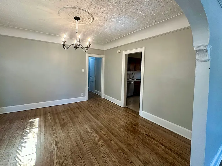 Spacious dining room with doorway to kitchen. Hallway to bedrooms and bathroom.